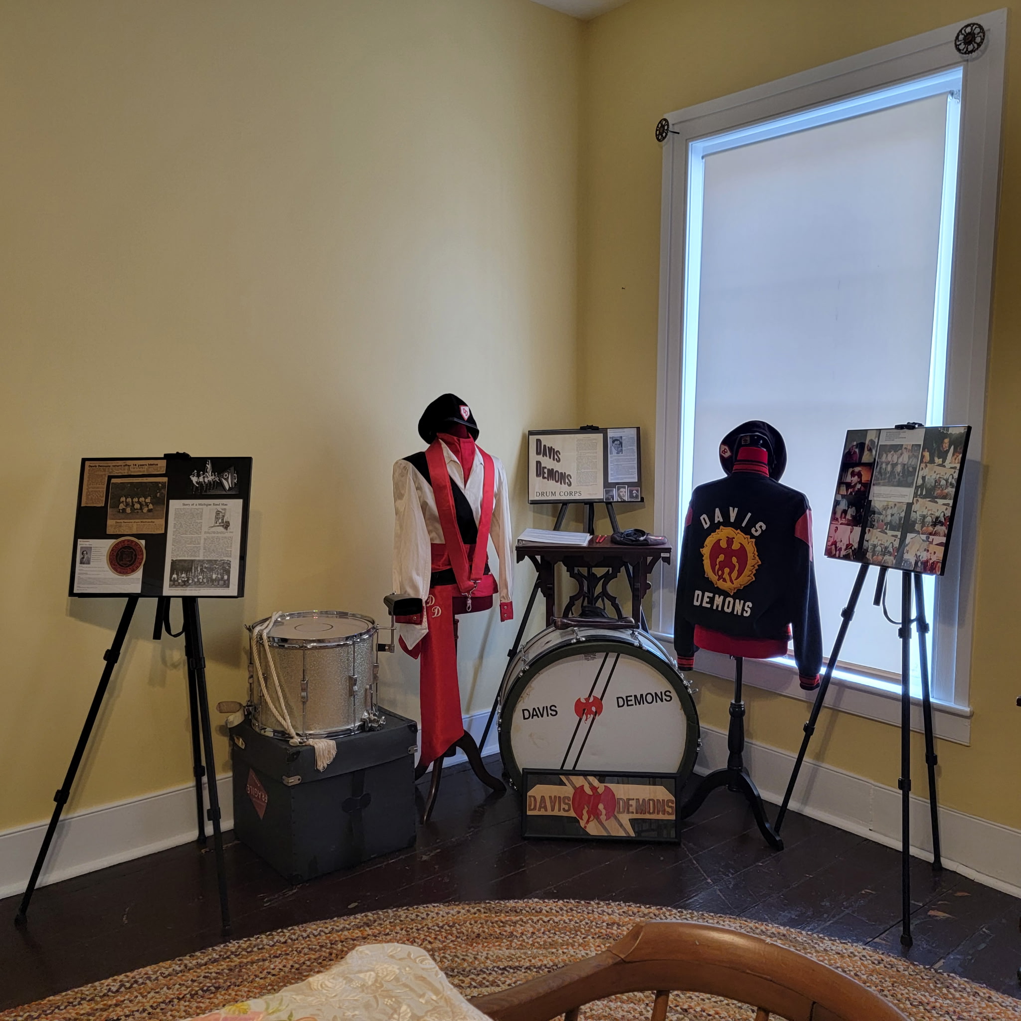 Davis Demons drum corps exhibit with drums, uniform and jacket