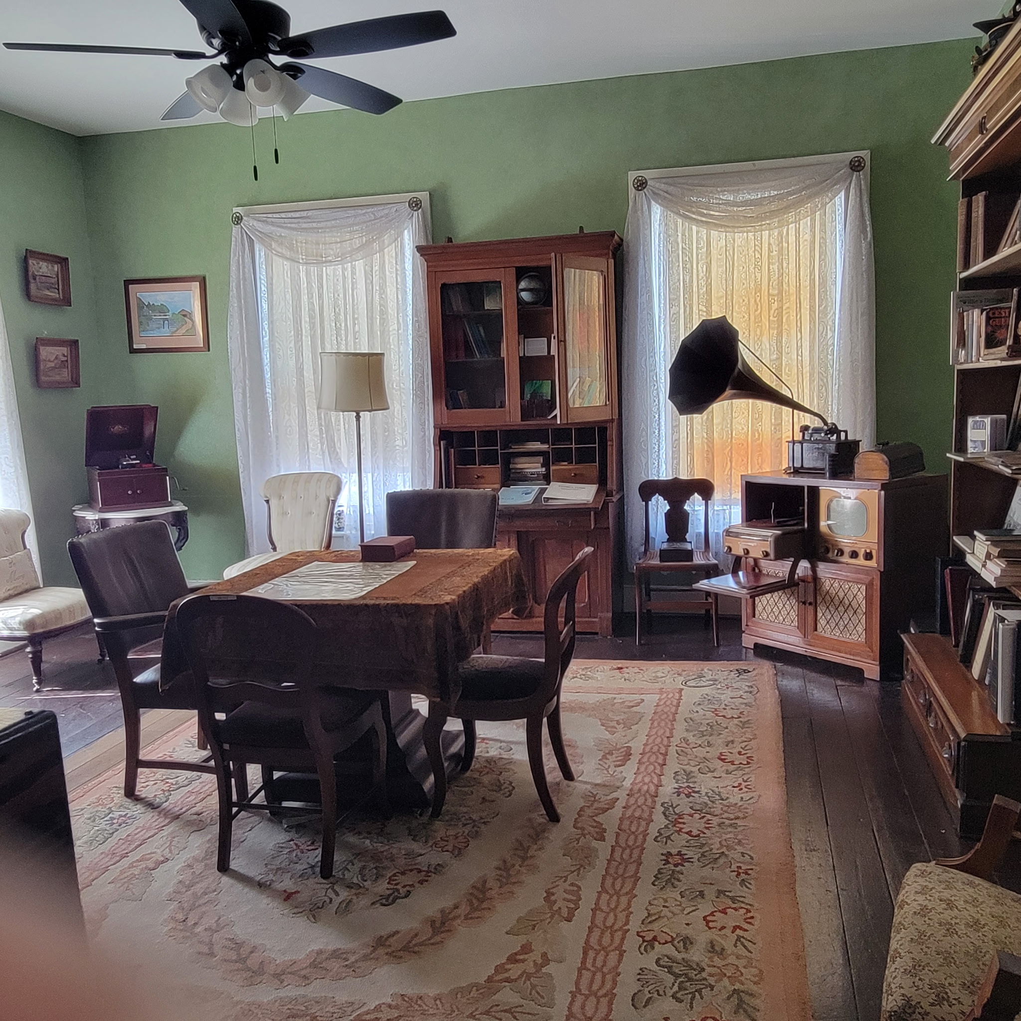 Green parlor with library table, gramophone and early television console