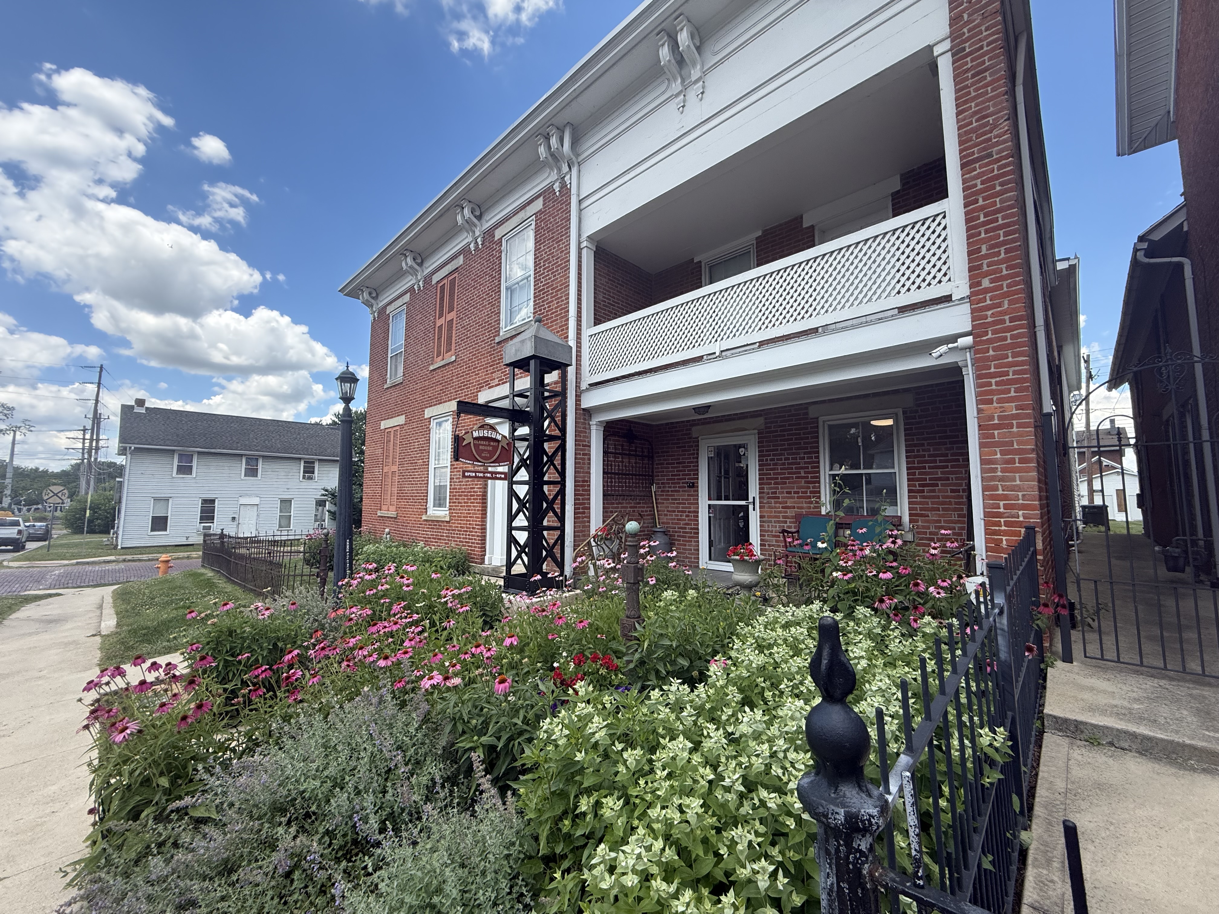 The museum porch framed by pink coneflowers in midsummer
