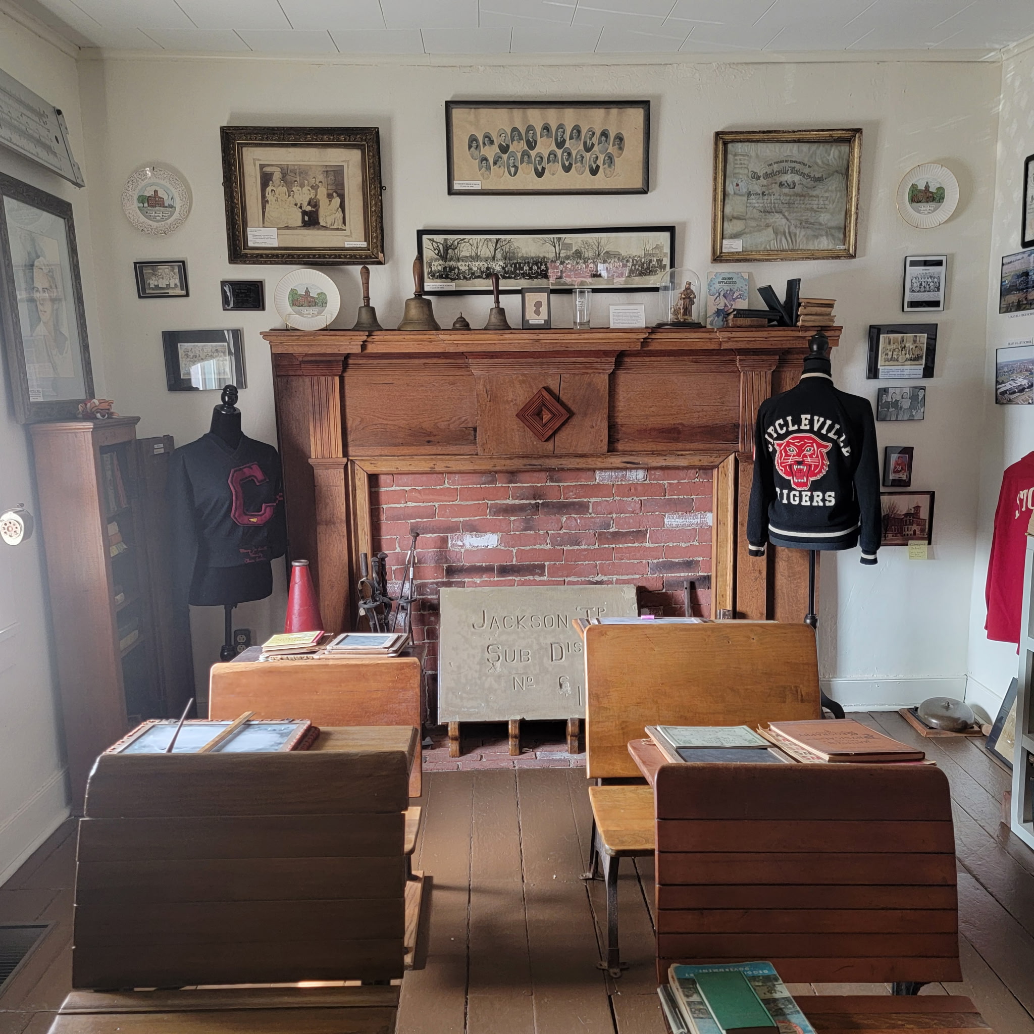 School exhibit mantel with class photographs and Circleville Tigers letter jackets