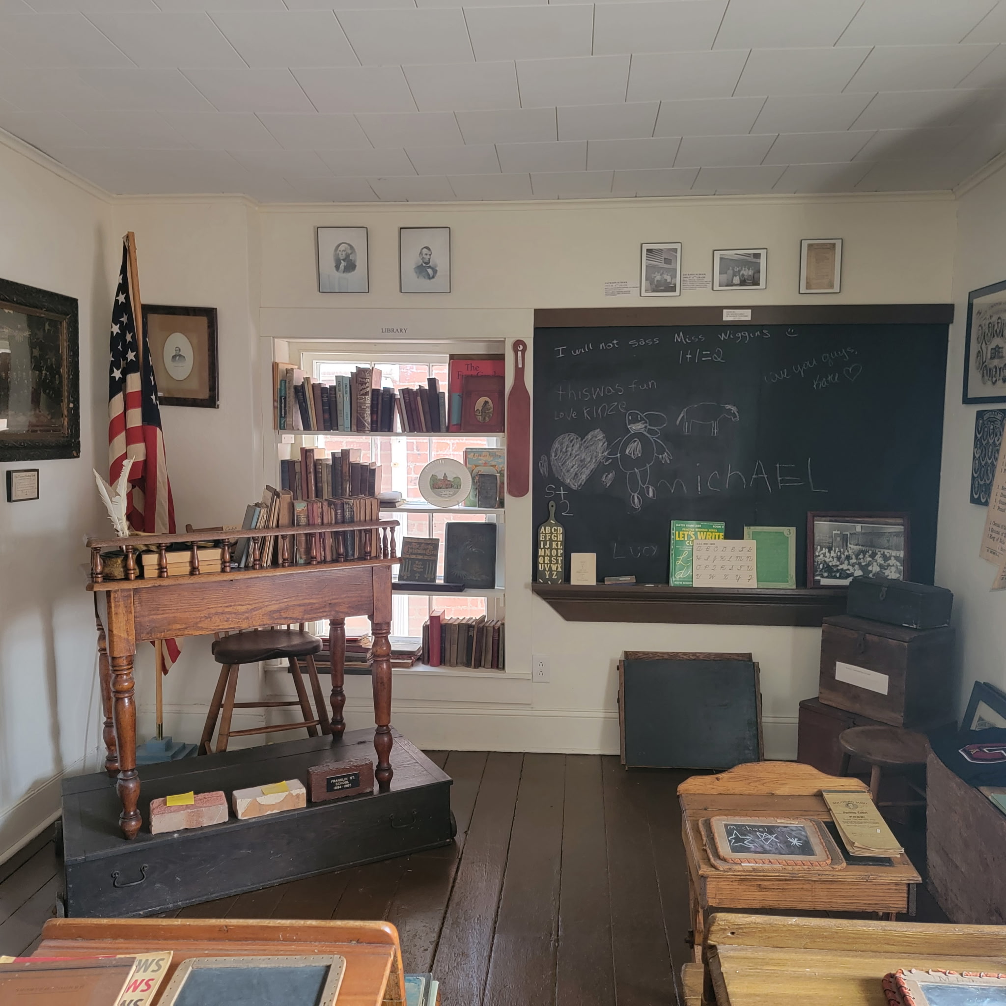 The one-room schoolhouse exhibit with chalkboard, desks and teacher’s table