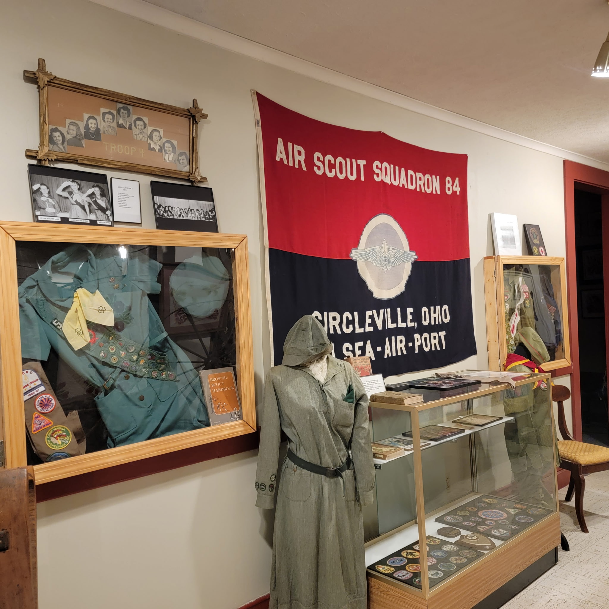 Scouting exhibit with uniforms and the Air Scout Squadron 84 banner