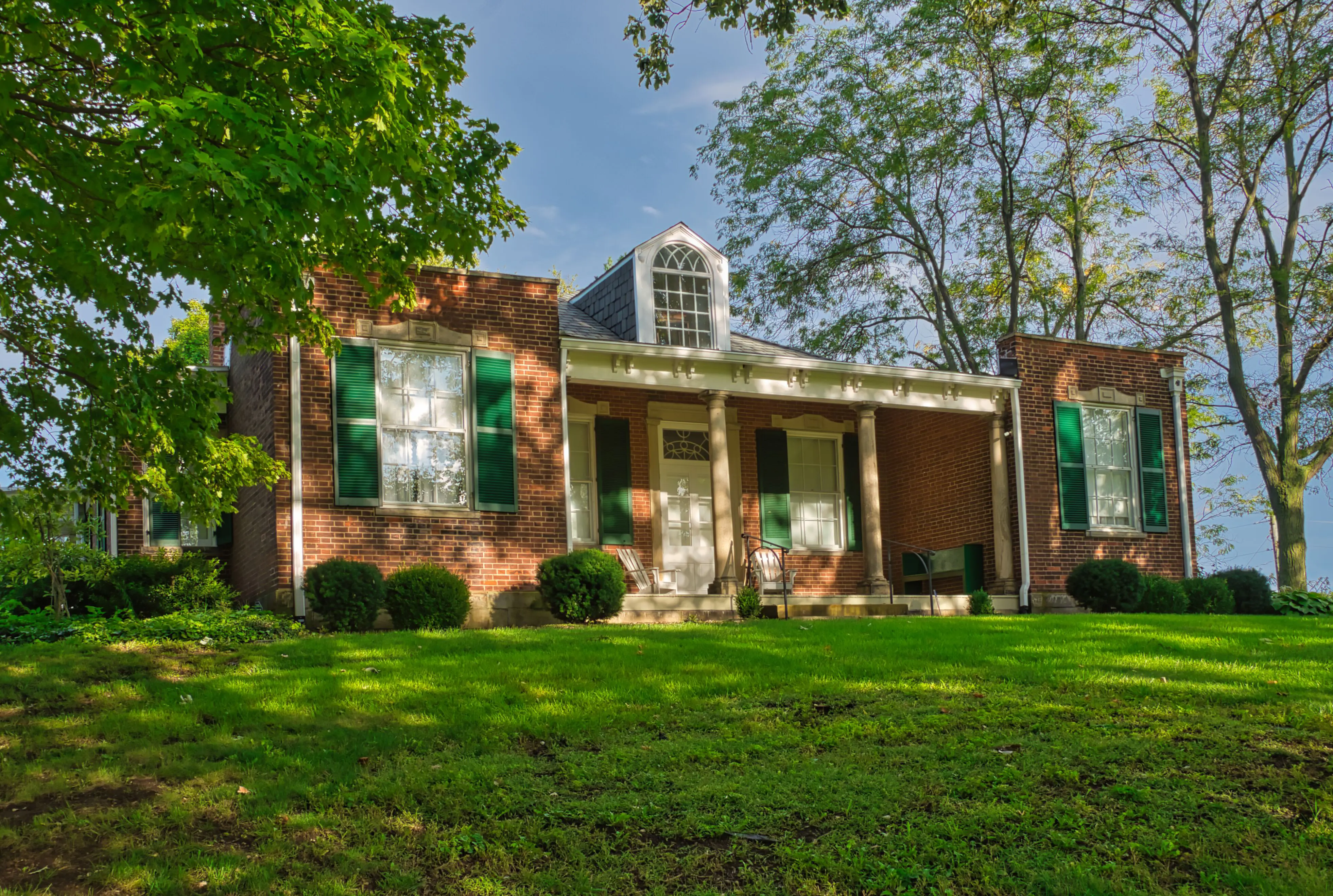 The Mount Oval farmhouse on its oval hill, framed by trees