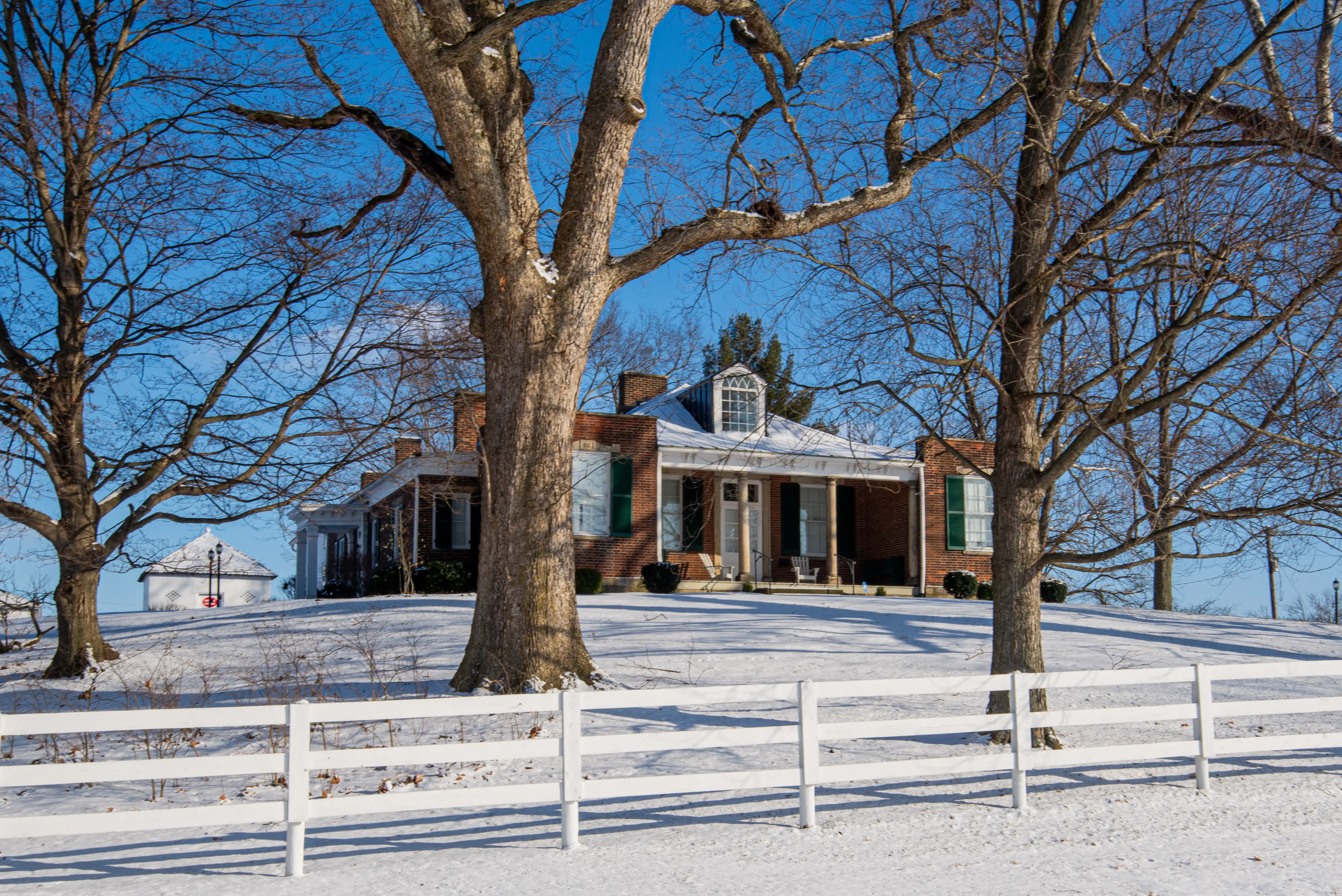 The Mount Oval farmhouse and white fence under snow