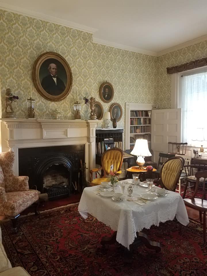 A sitting room at Mount Oval set for tea beneath family portraits