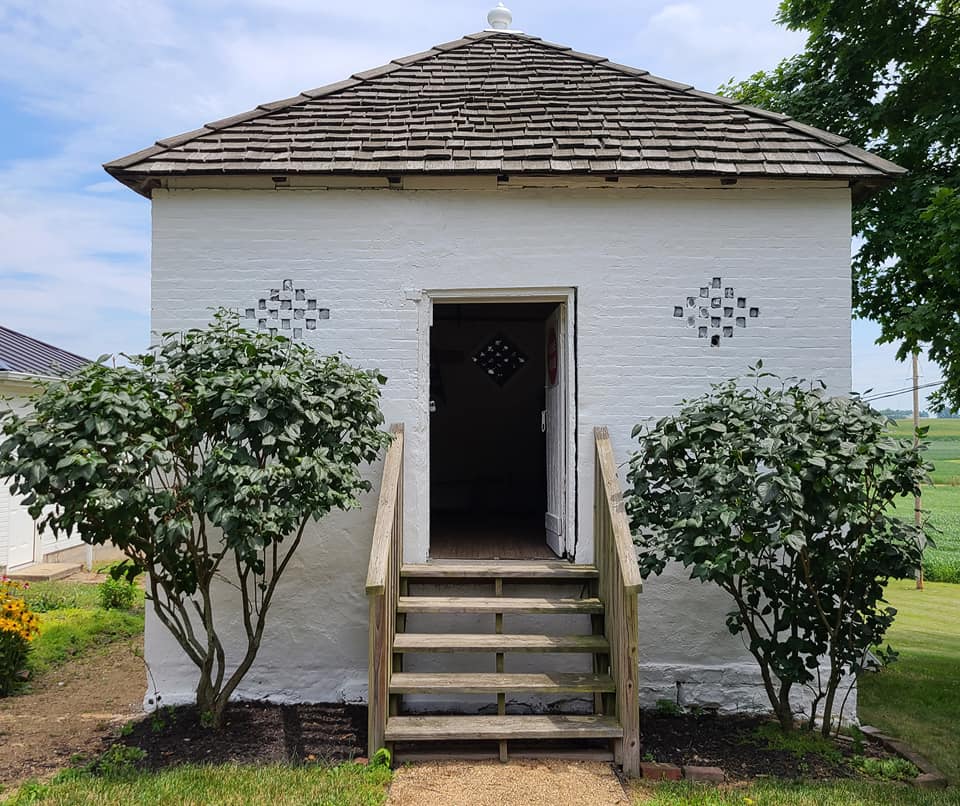 The whitewashed brick smokehouse at Mount Oval with its door open