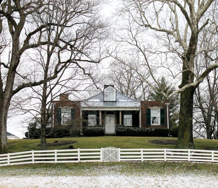 The Mount Oval farmhouse behind its white fence on a winter day